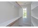 Well-organized walk-in closet with wood rods, white shelving and a window for natural light at 300 Silvercliff Trl, Cary, NC 27513