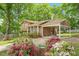 A charming home exterior featuring a carport, a cozy front porch, and vibrant flowering bushes at 300 Wakewood Ct, Raleigh, NC 27615