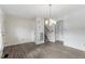 A spacious living room with hardwood floors, chandelier lighting, and access to the stairway at 300 Wakewood Ct, Raleigh, NC 27615