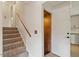Carpeted stairs with a wooden handrail lead to a hallway; nearby, a kitchen is visible at 300 Wakewood Ct, Raleigh, NC 27615