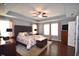Spacious primary bedroom with a decorative headboard, ceiling fan, and hardwood floors at 3032 Curling Creek Dr, Apex, NC 27502