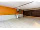 A spacious basement with white tile flooring, orange accent wall, and built-in shelves at 3209 Marie Dr, Raleigh, NC 27604