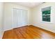 Bright bedroom features hardwood floors, a large window, and a closet with paneled doors at 3209 Marie Dr, Raleigh, NC 27604