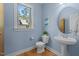 Stylish bathroom with blue walls, pedestal sink, toilet, and bright window at 3425 Donnigale Ave, Durham, NC 27705