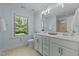 Well-lit bathroom boasts double vanity, tile floors, and a window providing ample natural light at 3425 Donnigale Ave, Durham, NC 27705