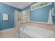 Beautiful bathroom featuring a soaking tub and glass-enclosed shower with tile surround at 3425 Donnigale Ave, Durham, NC 27705
