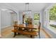 Charming dining room with wood table and benches and two windows overlooking lush greenery at 3425 Donnigale Ave, Durham, NC 27705