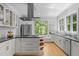 Bright kitchen with white cabinetry, stainless steel appliances, and a large window overlooking lush greenery at 3425 Donnigale Ave, Durham, NC 27705