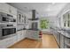 Modern kitchen with white cabinets, stainless steel appliances, and a view of the beautiful green backyard at 3425 Donnigale Ave, Durham, NC 27705