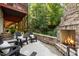 Outdoor stone fireplace with seating and a view of the wooded backyard at 3425 Donnigale Ave, Durham, NC 27705