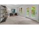 Bright sitting room features a pair of chairs, shelving, a large window and an exterior door at 3425 Donnigale Ave, Durham, NC 27705