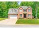 Charming two-story brick home featuring a well-manicured lawn and a two-car garage at 3436 Candlebrook Ct, Mebane, NC 27302