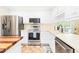Well-lit kitchen with white cabinets, stainless steel appliances, and ample counter space at 3436 Candlebrook Ct, Mebane, NC 27302