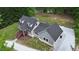 Aerial view of a gray home with a dark roof and surrounding green trees at 35 Fire Tower Dr, Rougemont, NC 27572