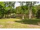 Beautiful yard with mature trees and gazebo overlooking the serene lake at 35 Fire Tower Dr, Rougemont, NC 27572