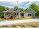 Charming gray home featuring a covered porch and well-maintained landscaping at 35 Fire Tower Dr, Rougemont, NC 27572