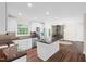 Bright kitchen featuring white cabinets, stainless steel appliances, island, and wood floors at 35 Fire Tower Dr, Rougemont, NC 27572