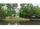 Scenic lake view with a charming gazebo, green trees, and the house in the background at 35 Fire Tower Dr, Rougemont, NC 27572