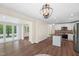 Inviting living room featuring hardwood floors, a modern kitchen, and abundant natural light from expansive windows at 35 Fire Tower Dr, Rougemont, NC 27572