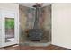 Close up of a stone fireplace and wood-burning stove in the living room, complemented by hardwood floors at 35 Fire Tower Dr, Rougemont, NC 27572