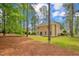 Large backyard featuring grass, mature trees, and a black fence at 35 Pine Water Way, Spring Lake, NC 28390