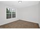 Bright bedroom featuring neutral carpet and paint, with a window at 35 Pine Water Way, Spring Lake, NC 28390