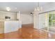 Open-concept dining area featuring hardwood floors, a chandelier, and sliding glass doors to a balcony at 4002 Cherry Blossom Cir, Durham, NC 27713