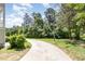 Long concrete driveway leading to a house, surrounded by well-maintained lawns and mature trees at 4002 Cherry Blossom Cir, Durham, NC 27713