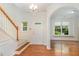 Bright foyer with hardwood floors, staircase, and arched entryway to living area at 4002 Cherry Blossom Cir, Durham, NC 27713
