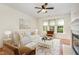 Staged living room with modern furniture, fireplace, ceiling fan, and natural light at 4002 Cherry Blossom Cir, Durham, NC 27713