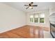 Bright living room with ceiling fan, hardwood floors, fireplace, and large windows at 4002 Cherry Blossom Cir, Durham, NC 27713