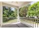 Covered porch with white railings, providing a serene outdoor space with views of the surrounding lush greenery at 4002 Cherry Blossom Cir, Durham, NC 27713