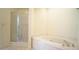 Bathroom featuring a glass-enclosed shower, large soaking tub with tile surround, and tile floors at 4024 Claret Ln, Morrisville, NC 27560