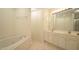 Bright bathroom featuring a soaking tub, double vanity with white cabinets, and ample counter space at 4024 Claret Ln, Morrisville, NC 27560