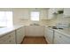 Bright kitchen features white cabinets, white appliances, and a double basin sink at 4024 Claret Ln, Morrisville, NC 27560