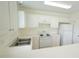 Kitchen boasts white cabinetry, appliances, countertops, and stainless steel double basin sink at 4024 Claret Ln, Morrisville, NC 27560