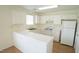 Well-lit kitchen features white cabinets, appliances, and a breakfast bar at 4024 Claret Ln, Morrisville, NC 27560