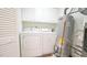 Functional laundry area with washer, dryer, water heater, and storage cabinets at 4024 Claret Ln, Morrisville, NC 27560