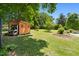 A wooden shed stands neatly in a spacious backyard under a clear blue sky at 416 Mitchell St, Hillsborough, NC 27278