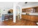 Home bar area featuring wood cabinets with glass fronts and dark countertops, open to the kitchen at 416 Mitchell St, Hillsborough, NC 27278