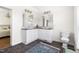 Bathroom featuring dual sinks, white cabinetry, and decorative rug at 416 Mitchell St, Hillsborough, NC 27278
