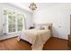 Bright bedroom with a large window, beautiful wood floors and a queen bed at 416 Mitchell St, Hillsborough, NC 27278