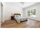 Well-lit bedroom with hardwood floors, a queen bed, and a window overlooking a green landscape at 416 Mitchell St, Hillsborough, NC 27278