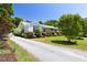 View of the exterior of the home showing the well-maintained gravel driveway and lush landscaping at 416 Mitchell St, Hillsborough, NC 27278