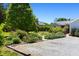 A landscaped yard with a gravel driveway leads to the charming home at 416 Mitchell St, Hillsborough, NC 27278