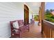Relaxing front porch with wood flooring, bench seating, and views of the surrounding greenery at 416 Mitchell St, Hillsborough, NC 27278