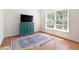 Bright living room featuring hardwood floors, a large window, and a decorative blue cabinet at 416 Mitchell St, Hillsborough, NC 27278