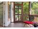 Inviting screened-in porch with outdoor furniture, a door, and a glimpse of a friendly dog at 416 Mitchell St, Hillsborough, NC 27278