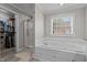 Bright bathroom featuring a soaking tub, glass shower, and a walk-in closet at 4589 Freedom Dr, Burlington, NC 27215