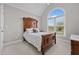 Bedroom featuring an arched window, vaulted ceilings, neutral carpet, and a wooden sleigh bed at 4589 Freedom Dr, Burlington, NC 27215